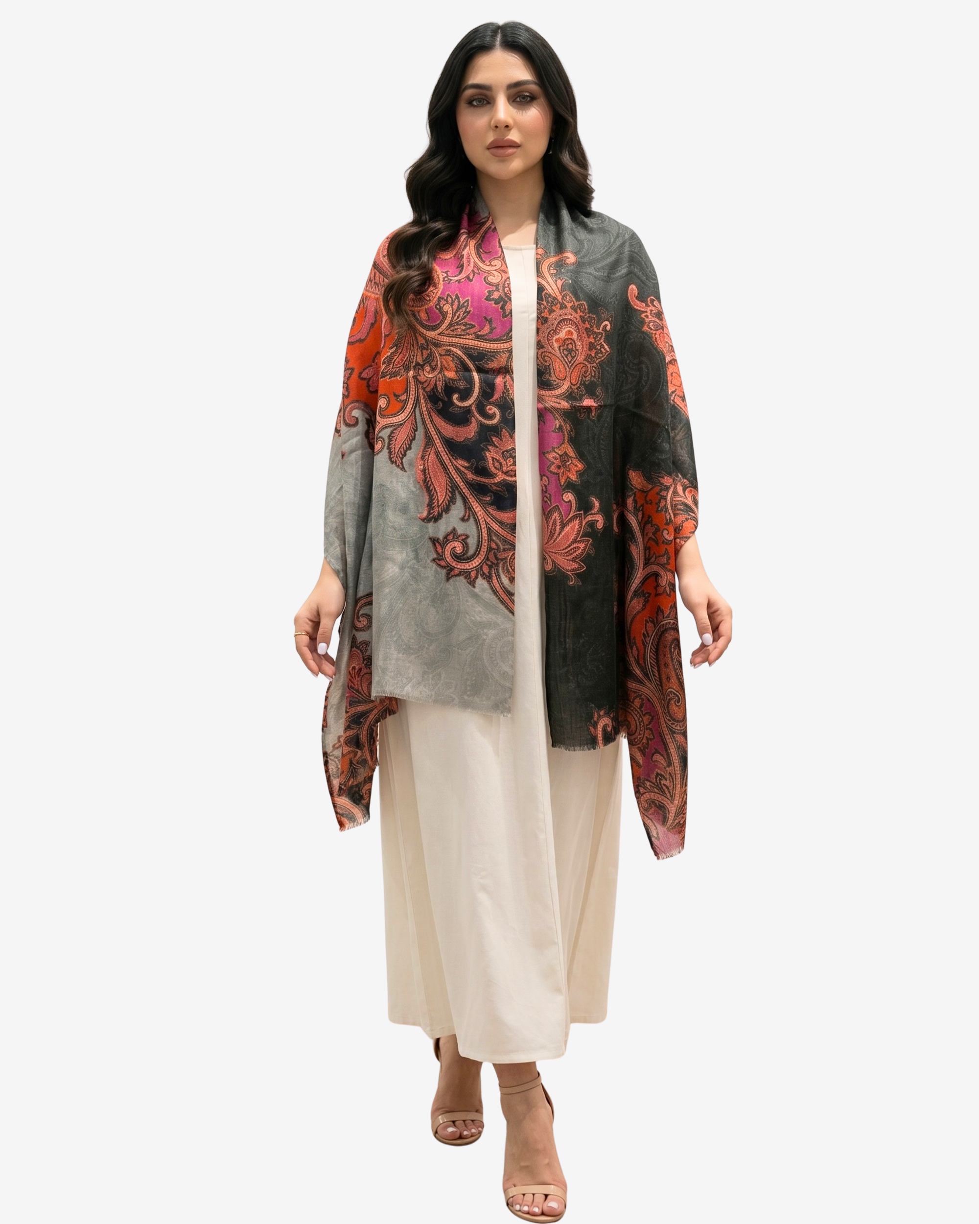 A woman modeling a lightweight open-front shawl with a complex paisley and floral print in orange, red, pink, and gray, worn over a cream-colored kurta and trousers.