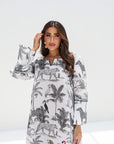 Woman wearing a long dress with animal and plant pattern on a white background