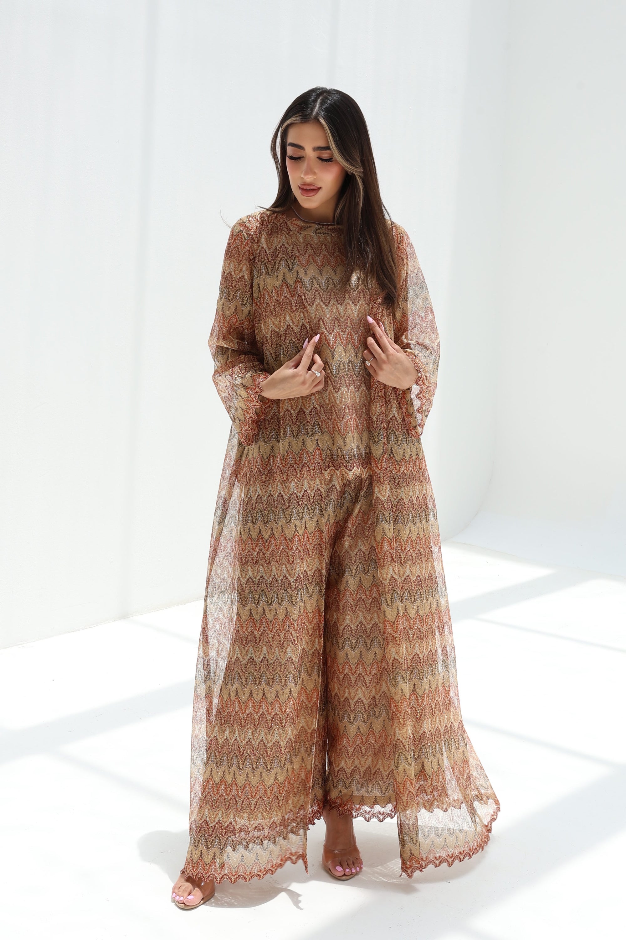 Three-quarter view of sand-toned three-piece set with a long lace outer layer