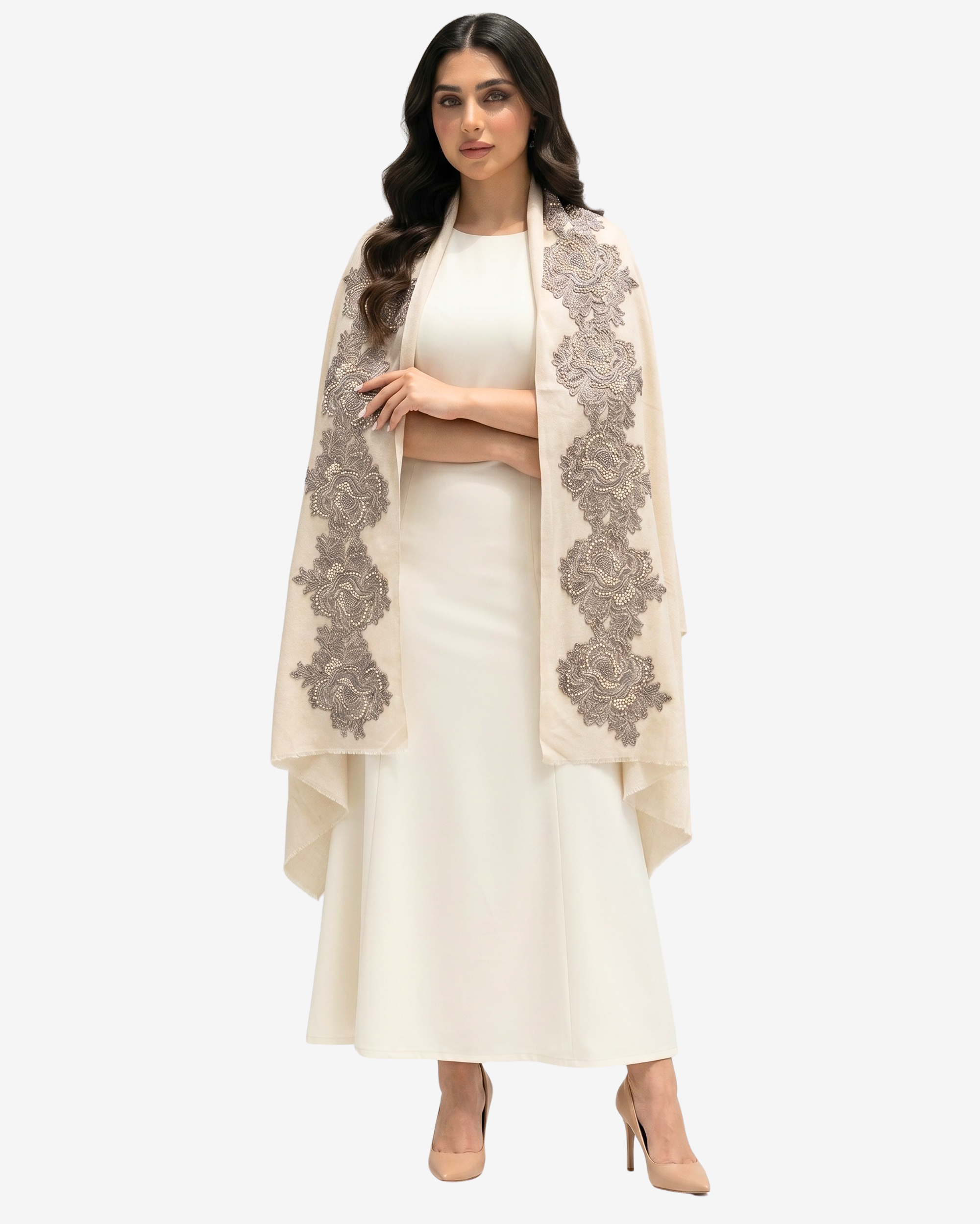 A woman modeling a cream-colored traditional outfit with a matching long skirt and crop top, draped with a sheer beige shawl featuring large gray floral lace patterns, set against a plain light gray background.