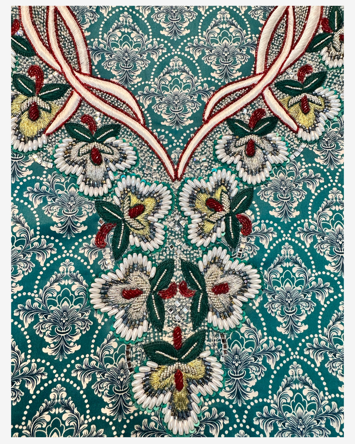 Close-up of ivory, red, green and gold floral beadwork on teal Japanese Liberty cotton mukhawar fabric.