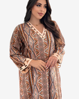 A woman modeling a long-sleeve bohemian-style maxi dress with a geometric tribal print in brown, beige, and orange tones, featuring a V-neckline and ruffled cuffs, set against a plain light gray background.