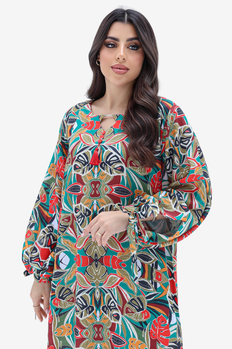 A woman modeling a long-sleeved, loose-fitting tunic dress with a vibrant, multicolor abstract pattern on a light gray background.