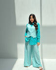 Women's three-piece travel wear outfit in aqua blue with relaxed and elegant styling.
