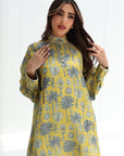 Woman wearing a yellow floral dress against a white background