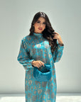 Woman wearing a blue traditional outfit with floral patterns on a gray background