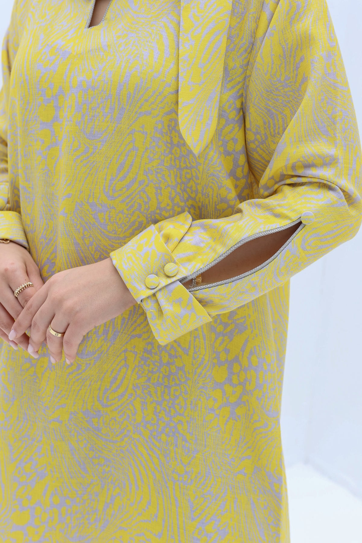 Close-up of Yellow Abstract Linen Blend Jalabiya sleeve featuring slit cuff and decorative button details.